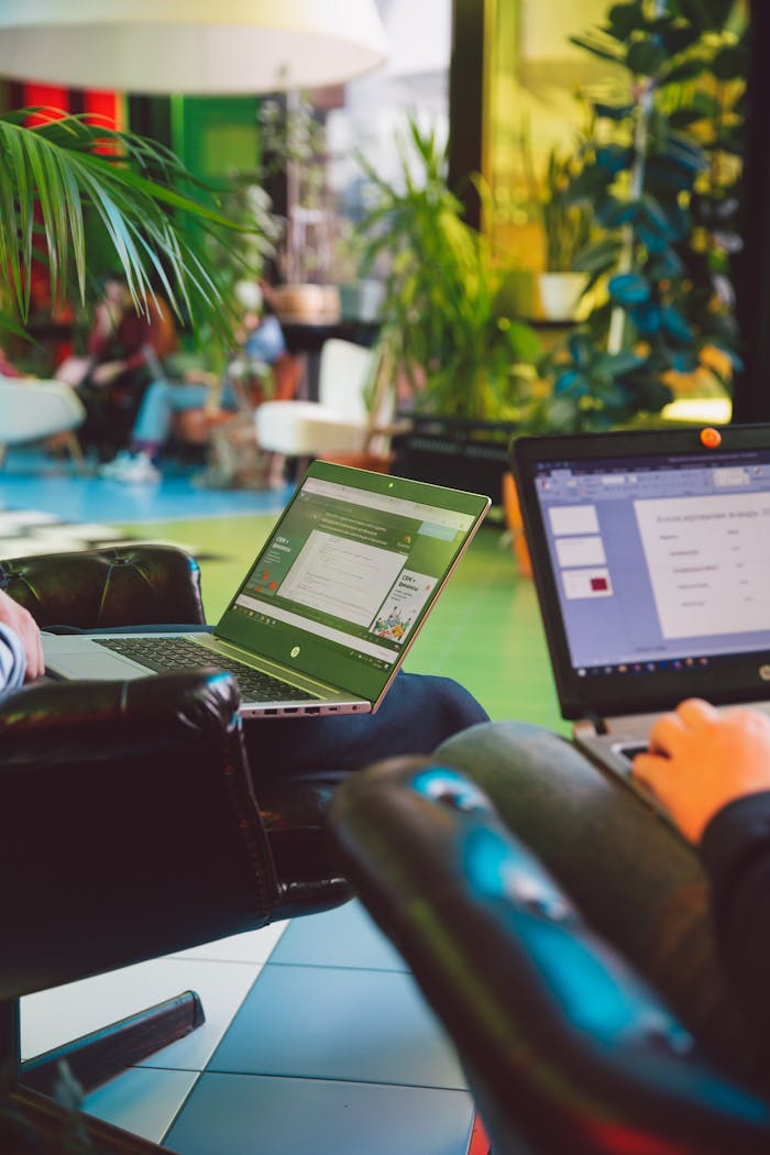 Modern workspace with people using laptops amidst vibrant indoor plants.